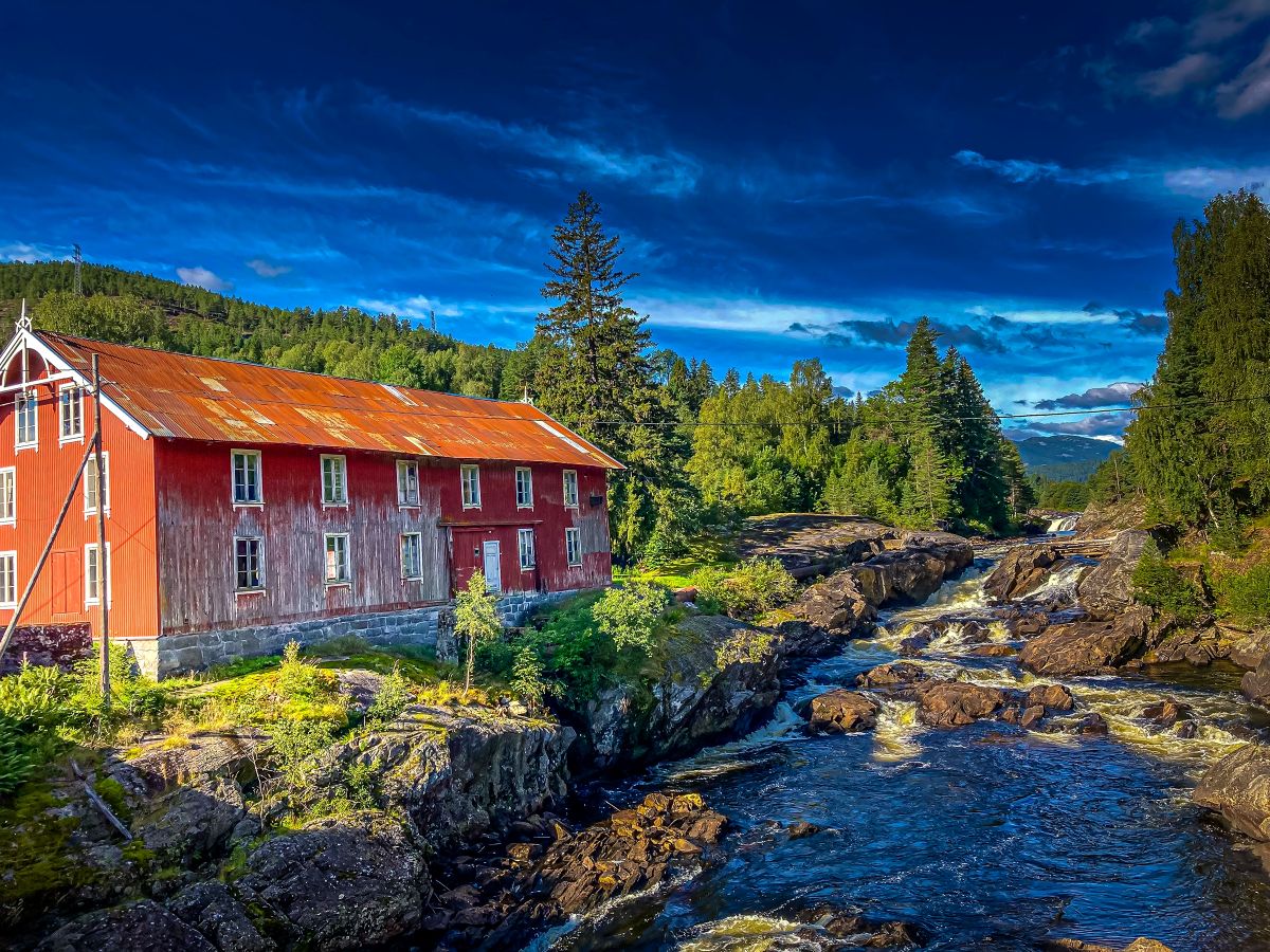 flod med ett falurott hus intill